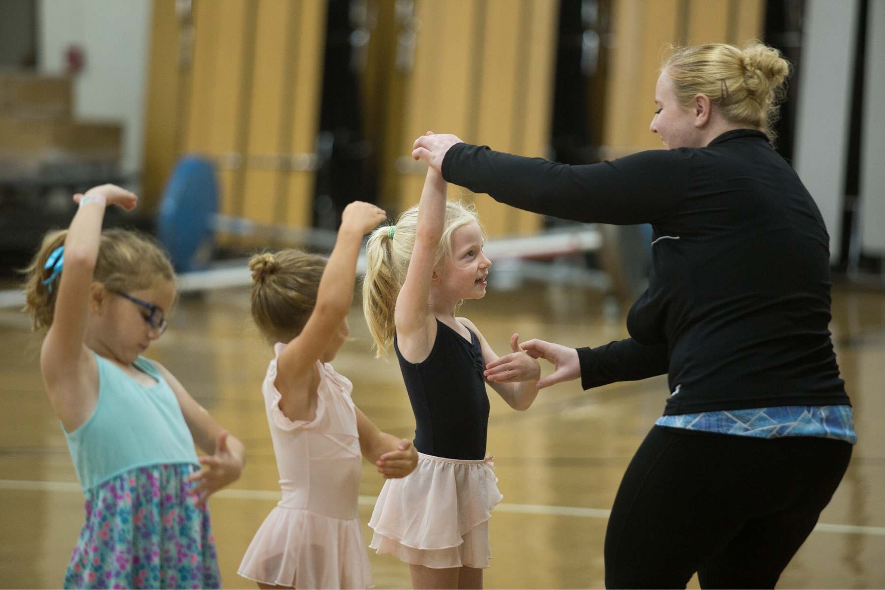 instructor helps dance student